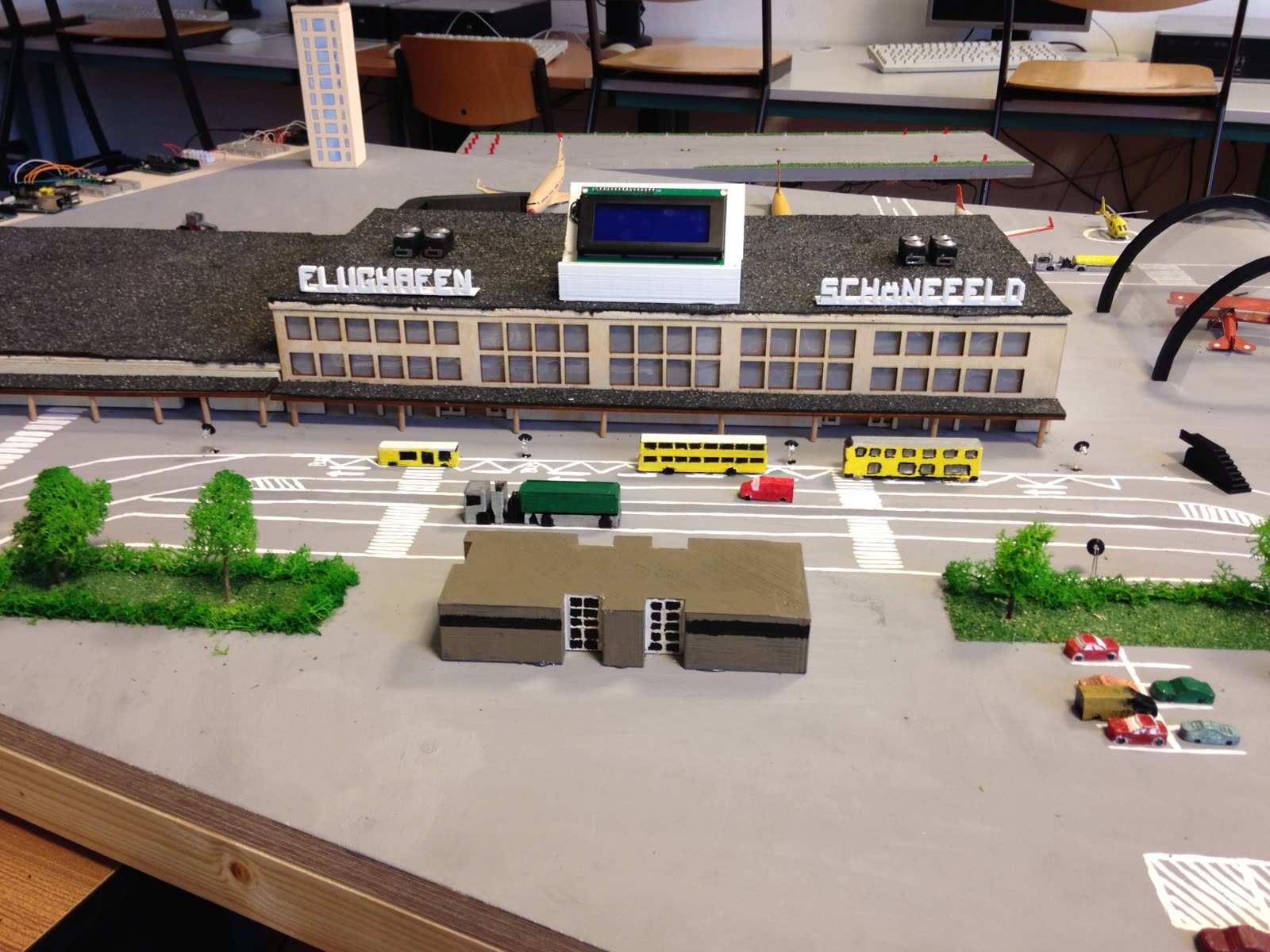 Modell-Terminal mit der Aufschrift „Flughafen Schönefeld“, davor Busse, Vorfahrt und Parkplätze
