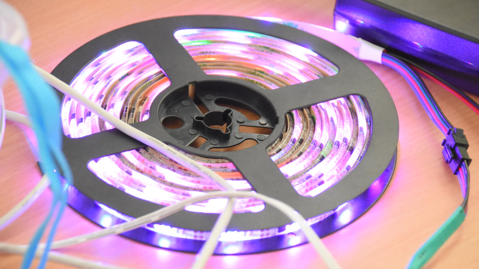 Rolle eines bunt leuchtenden LED-Streifens mit Anschlusskabeln