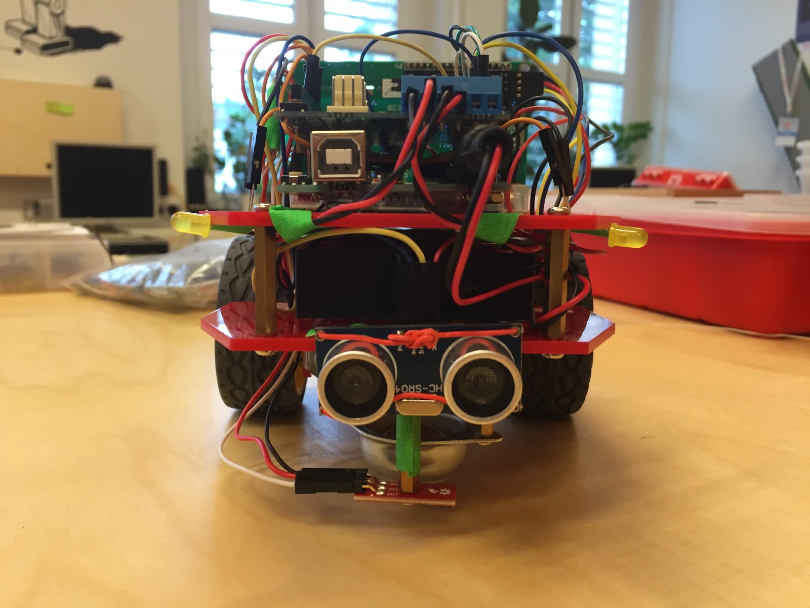 Roboterfahrzeug mit Arduino, vielen bunten Kabeln und Ultraschallsensor vorne