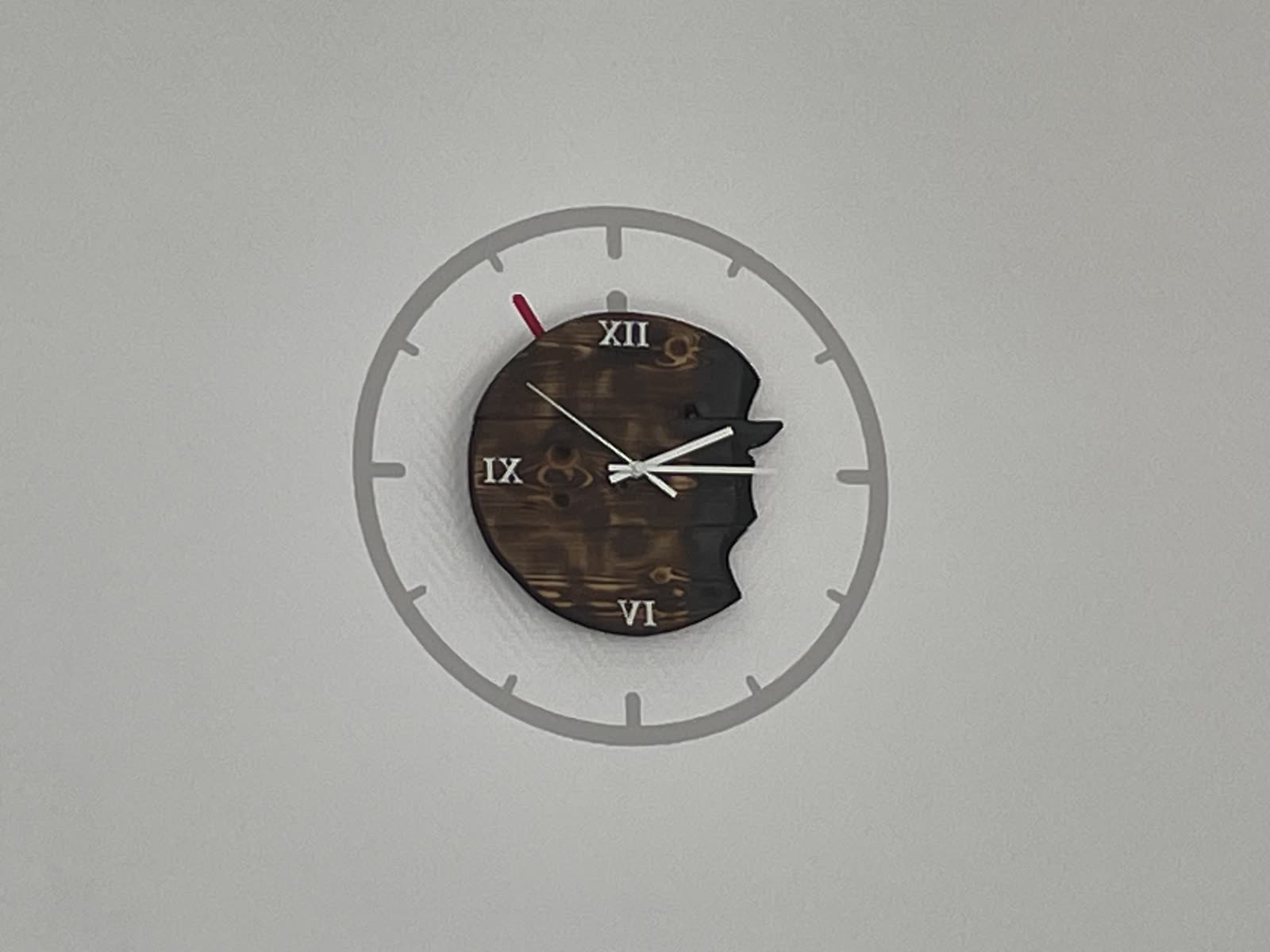 Wanduhr mit aufgeklebtem Ziffernblatt-Ring aus Folie an einer weißen Wand